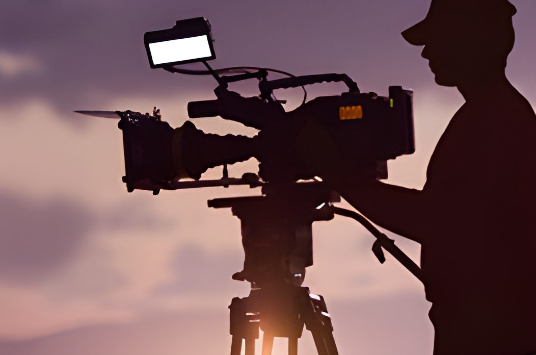 Camera operator silhouetted at sunset